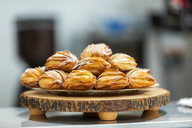 Tray of golden filled pastries dusted with sugar