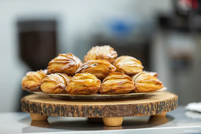 Tray of golden filled pastries dusted with sugar