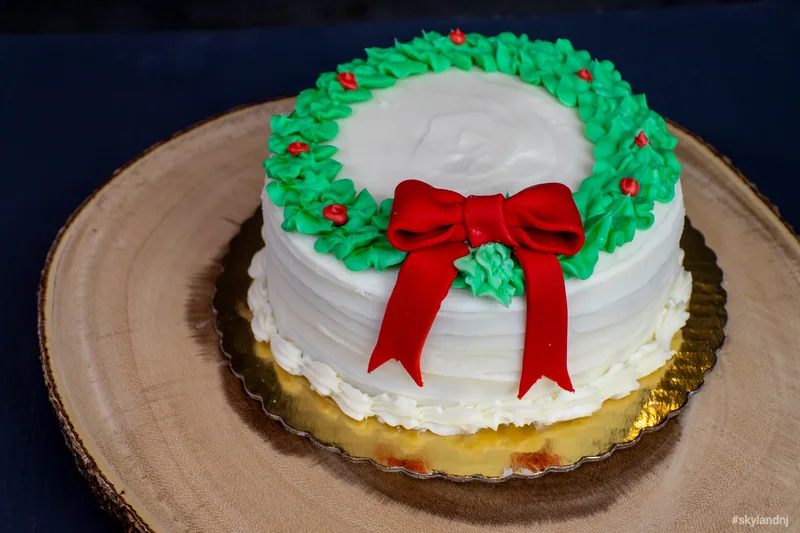 White cake decorated with a red bow and green wreath